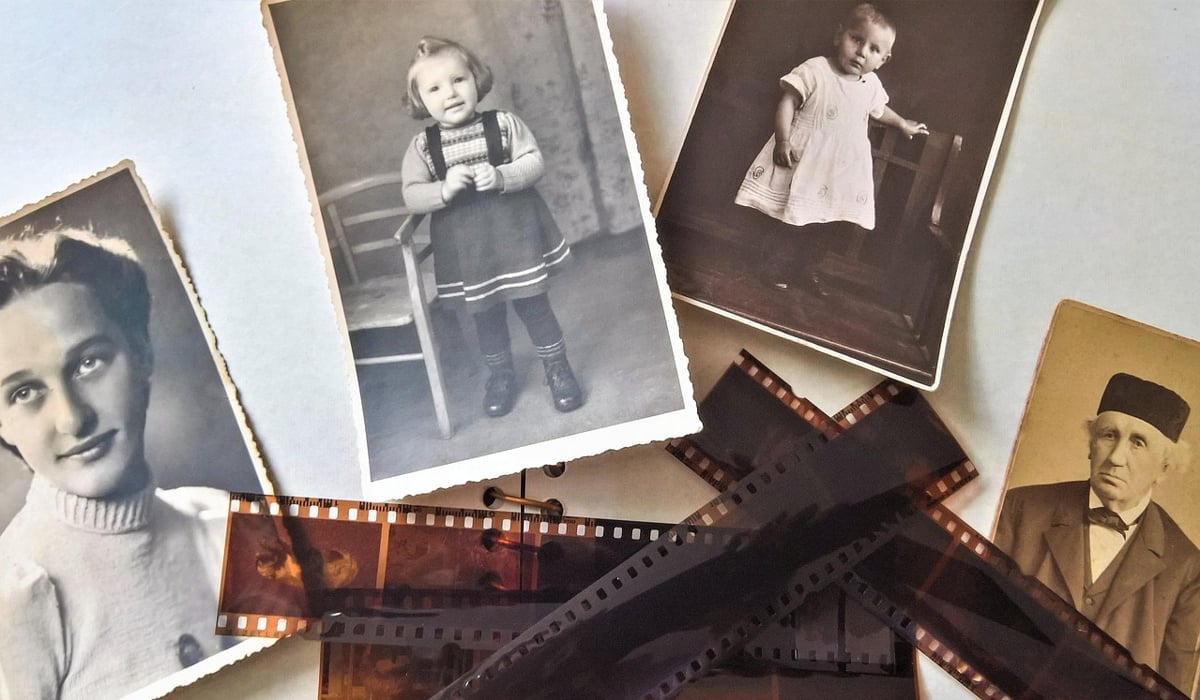 Äldre svartvita porträtt och några negativ placerade på ett bord.