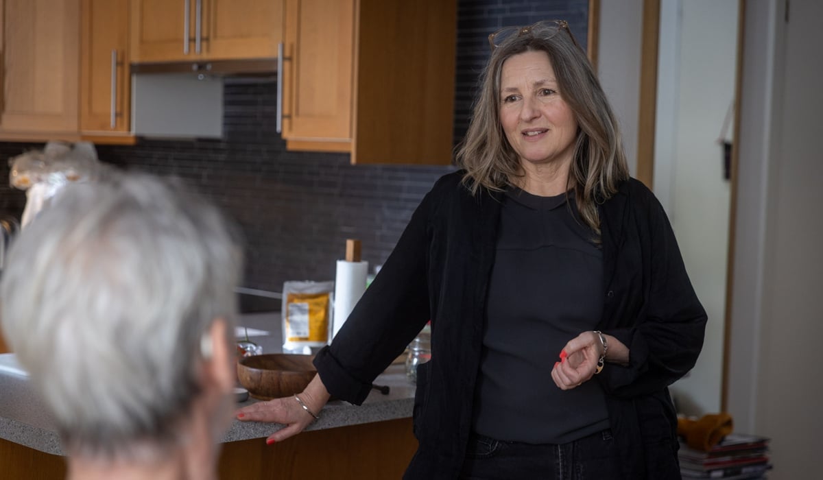 En kvinna pratar med en man i ett kök.