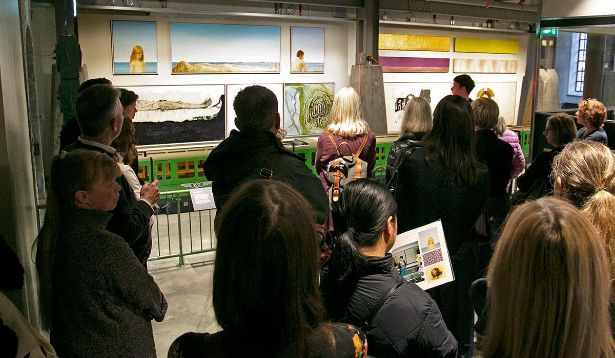 Grupper människor tittar på konsten på Spårvägsmuseet.