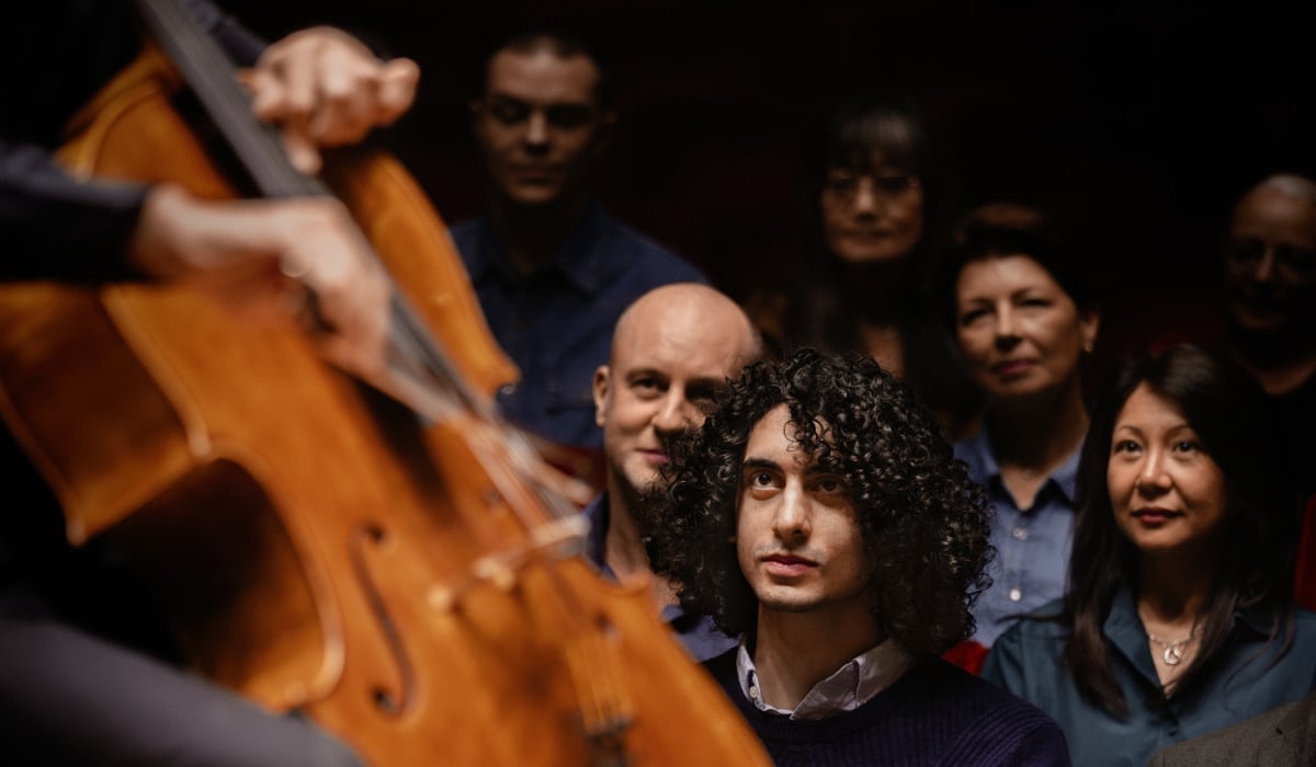 Flera människor sitter och lyssnar på en konsert. I förgrunden syns en cello.