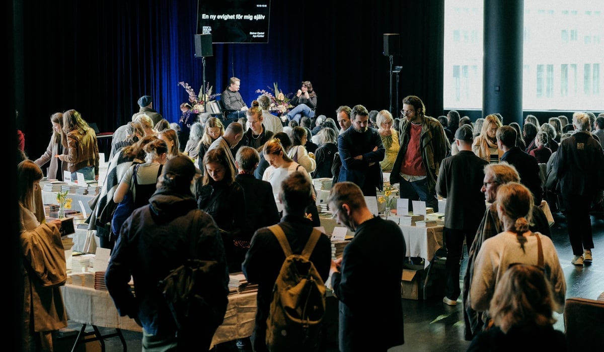 En stor grupp människor som står runt ett rum.