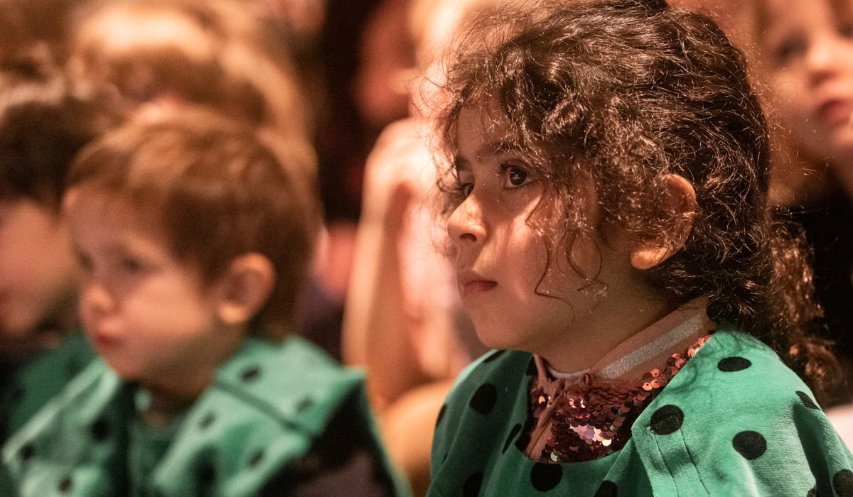 En grupp barn som sitter bredvid varandra.