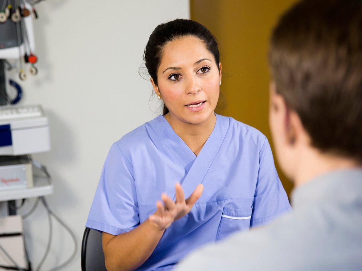 Kvinnlig läkare samtalar med patient
