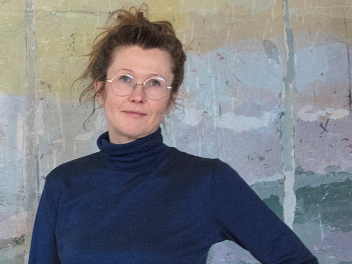 Petra står med armen i sidan och tittar i i kameran.