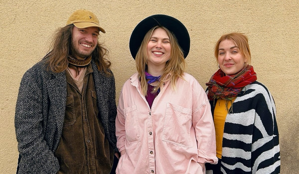 Tre leende personer, en man och två kvinnor.