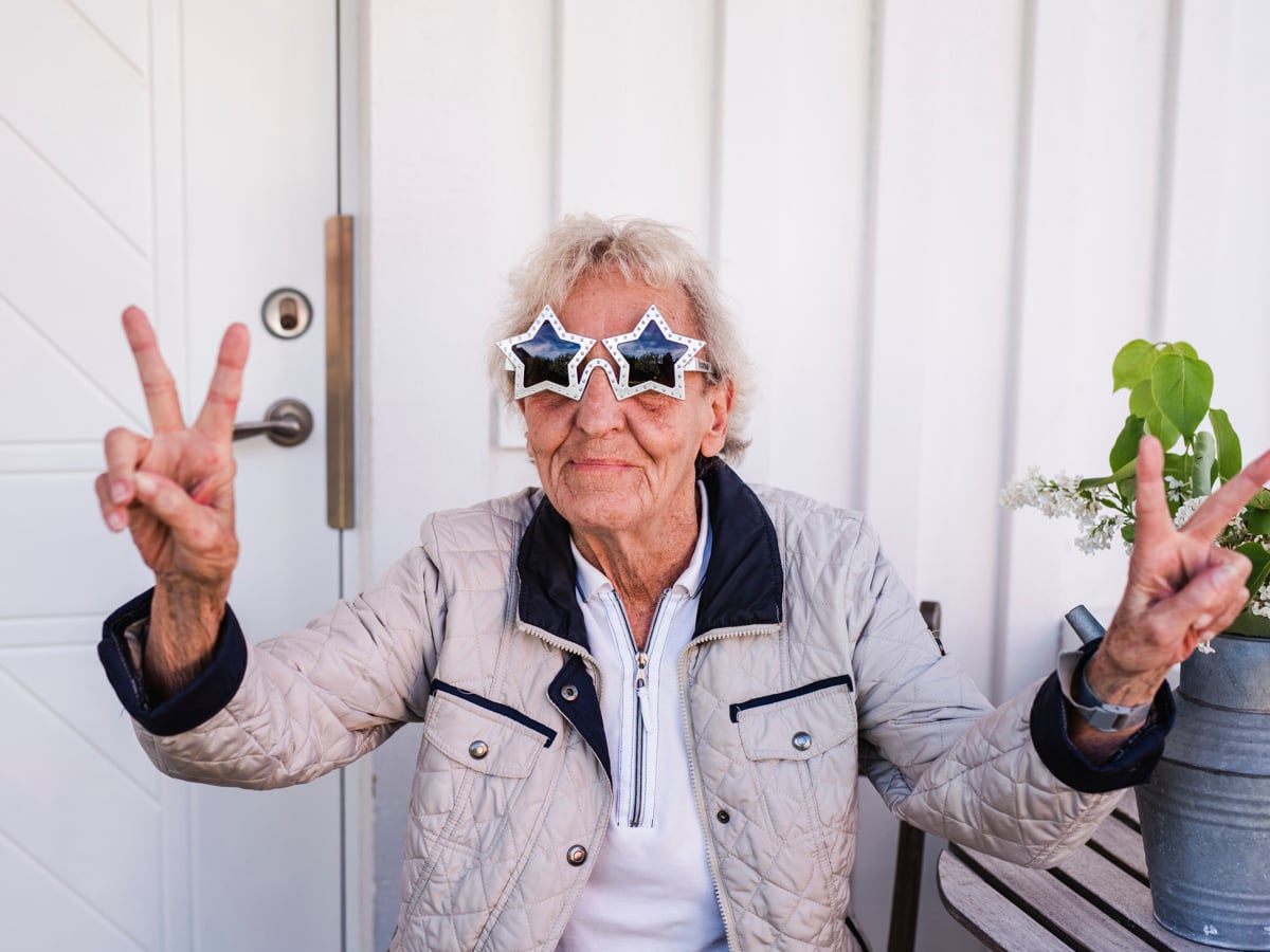 Bild på glad kvinna iförd stjärnformade glasögon.