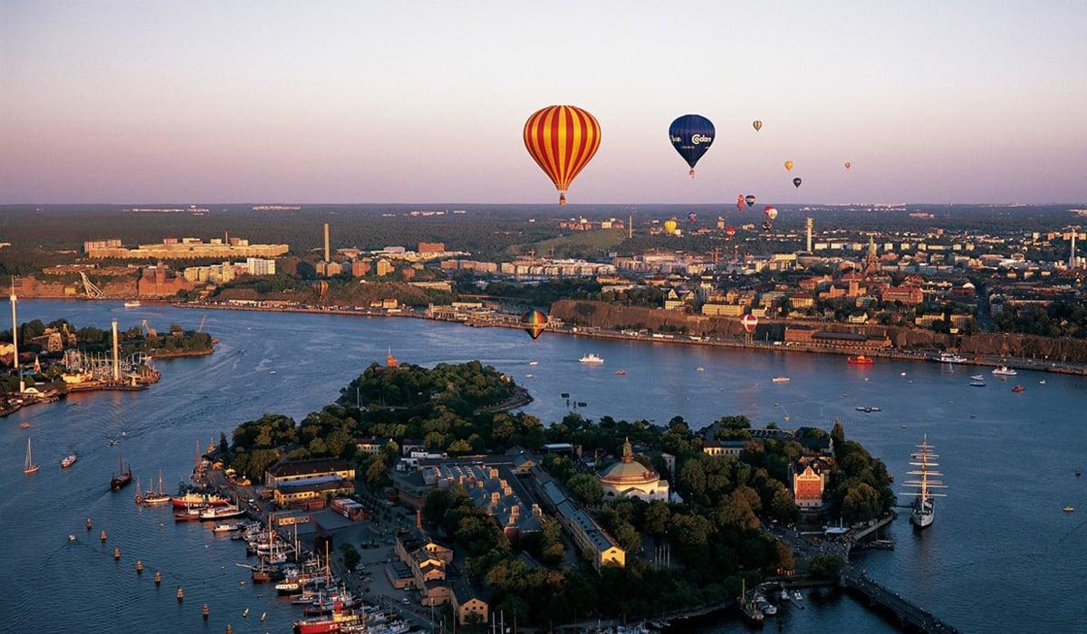 Flygbild över Skeppsholmen. I bakgrunden syns Nacka. Vi ser också flertalet färgglada luftballonger