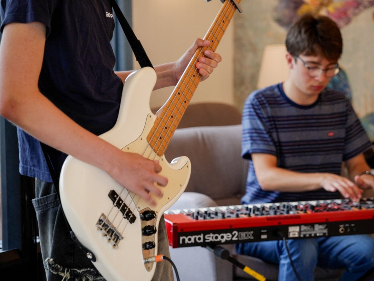 Två unga killar spelar musik, en spelar elbas och en keyboard.