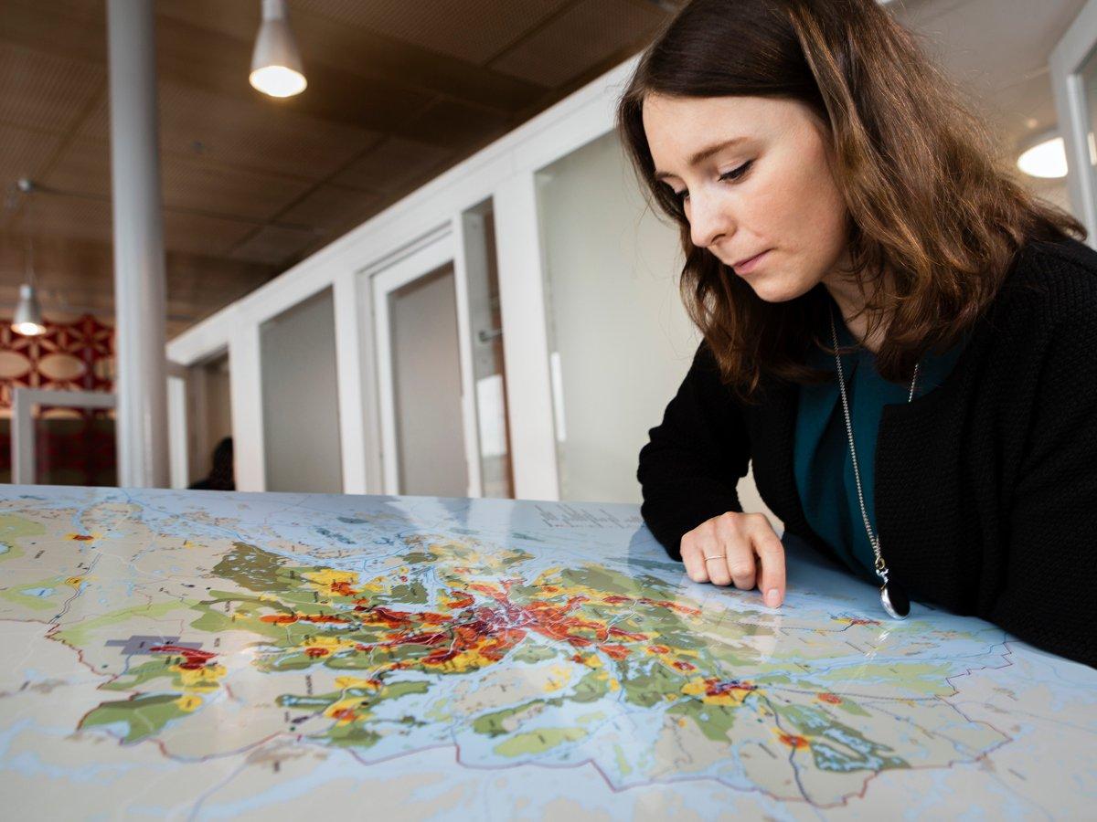 Kvinna kollar på karta över Stockholms län