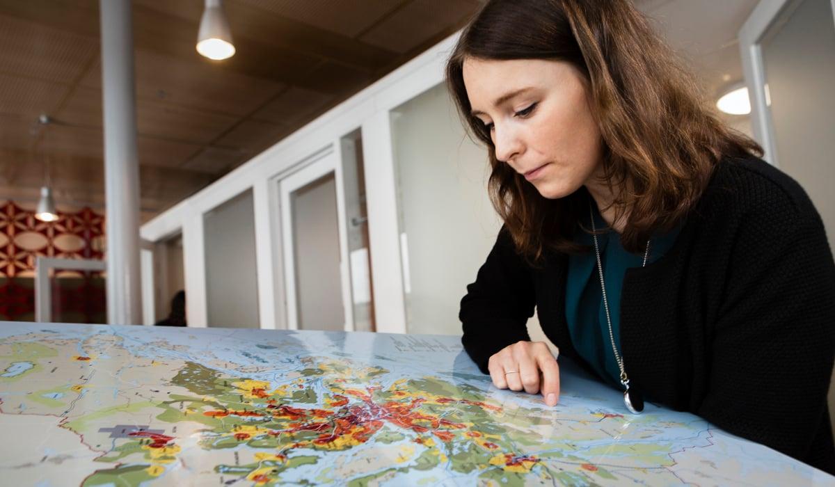 Kvinna kollar på karta över Stockholms län