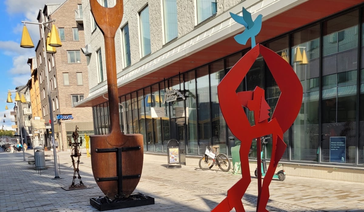 Några stora metallskulpturer som står på en gata.