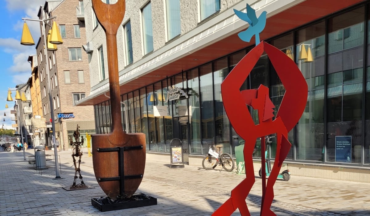 Några stora metallskulpturer som står på en gata.