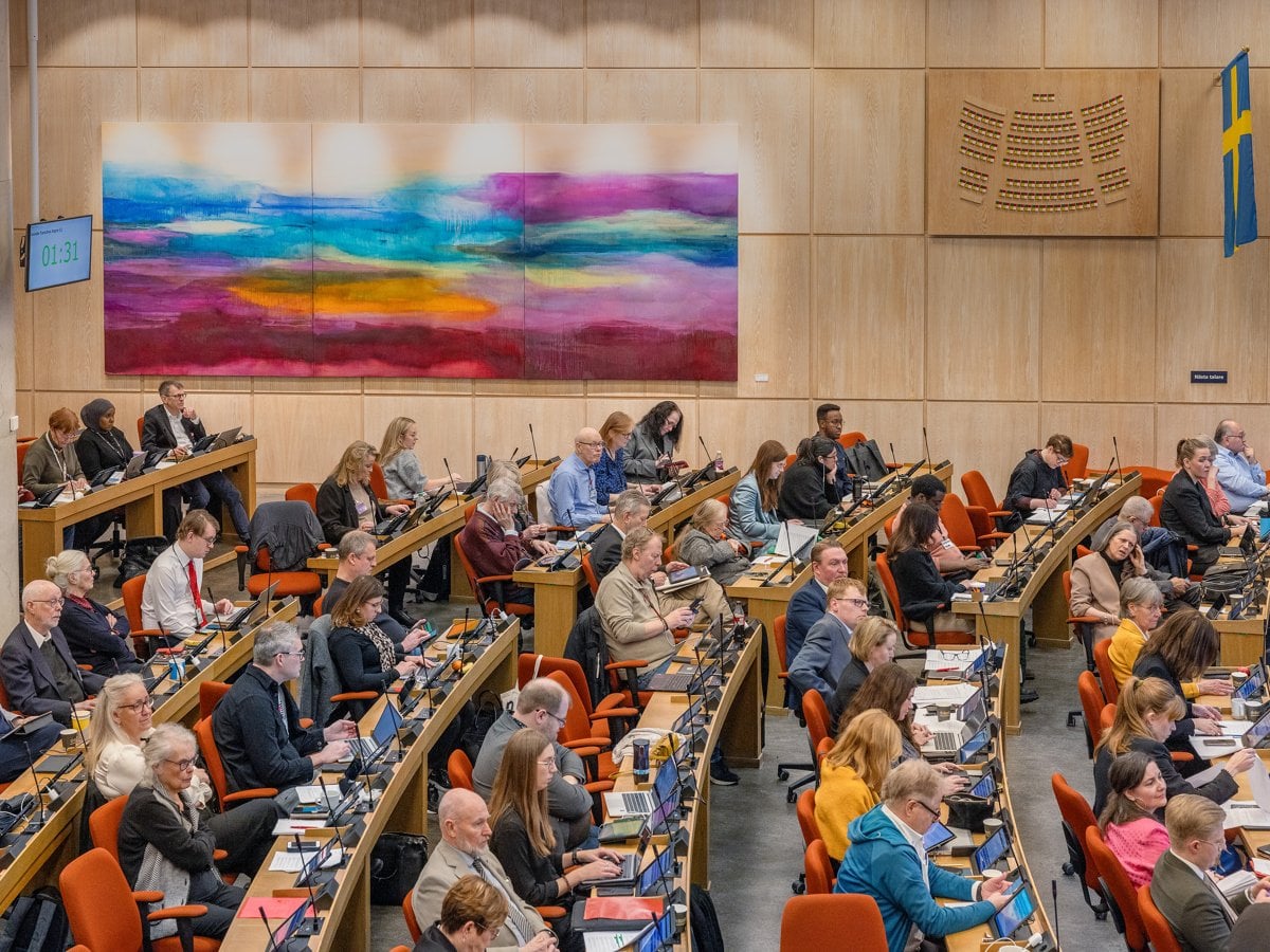 En grupp människor som sitter vid bord i ett rum