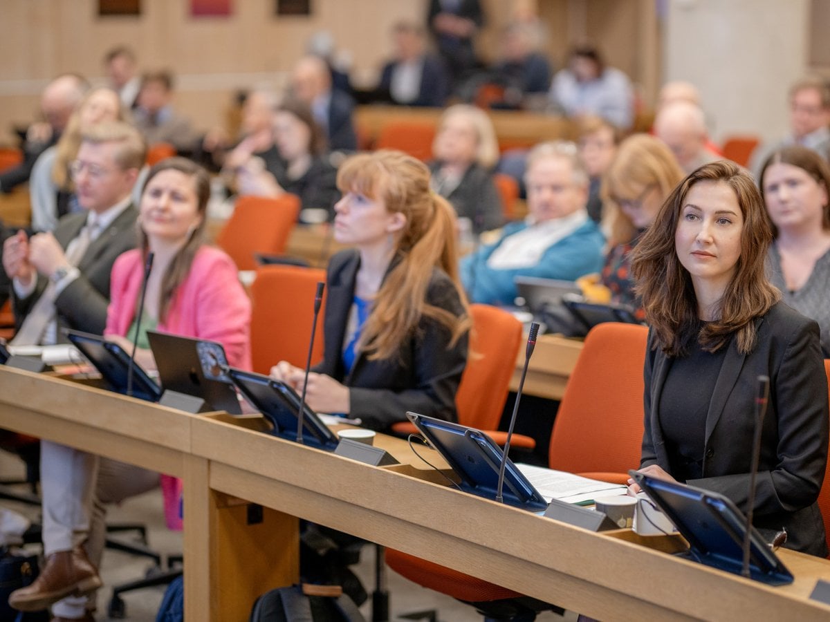 En grupp människor som sitter i ett rum med bärbara datorer