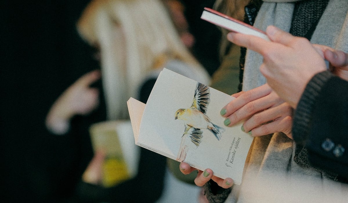 Personer som står vid ett bord med böcker.