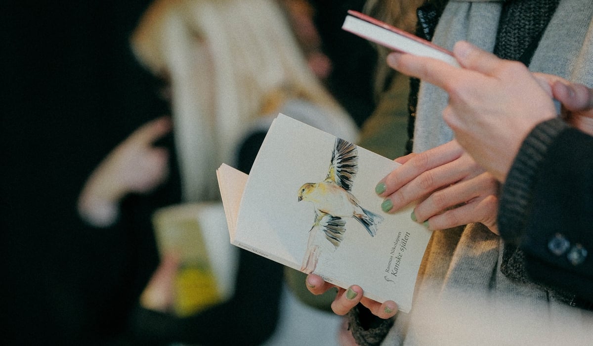 Personer som står vid ett bord med böcker.