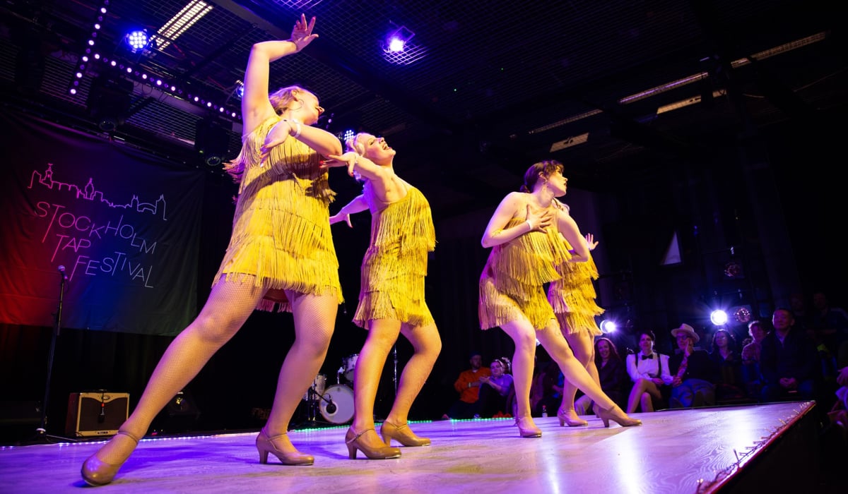 En grupp kvinnor i gula klänningar på en scen.