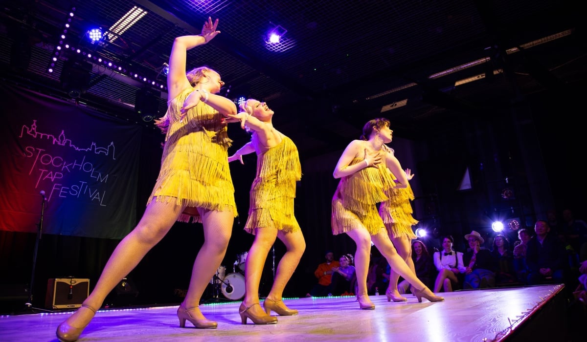 En grupp kvinnor i gula klänningar på en scen.