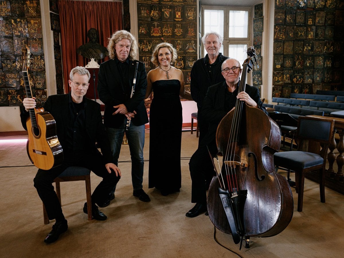 Fem musiker poserar med instrument.