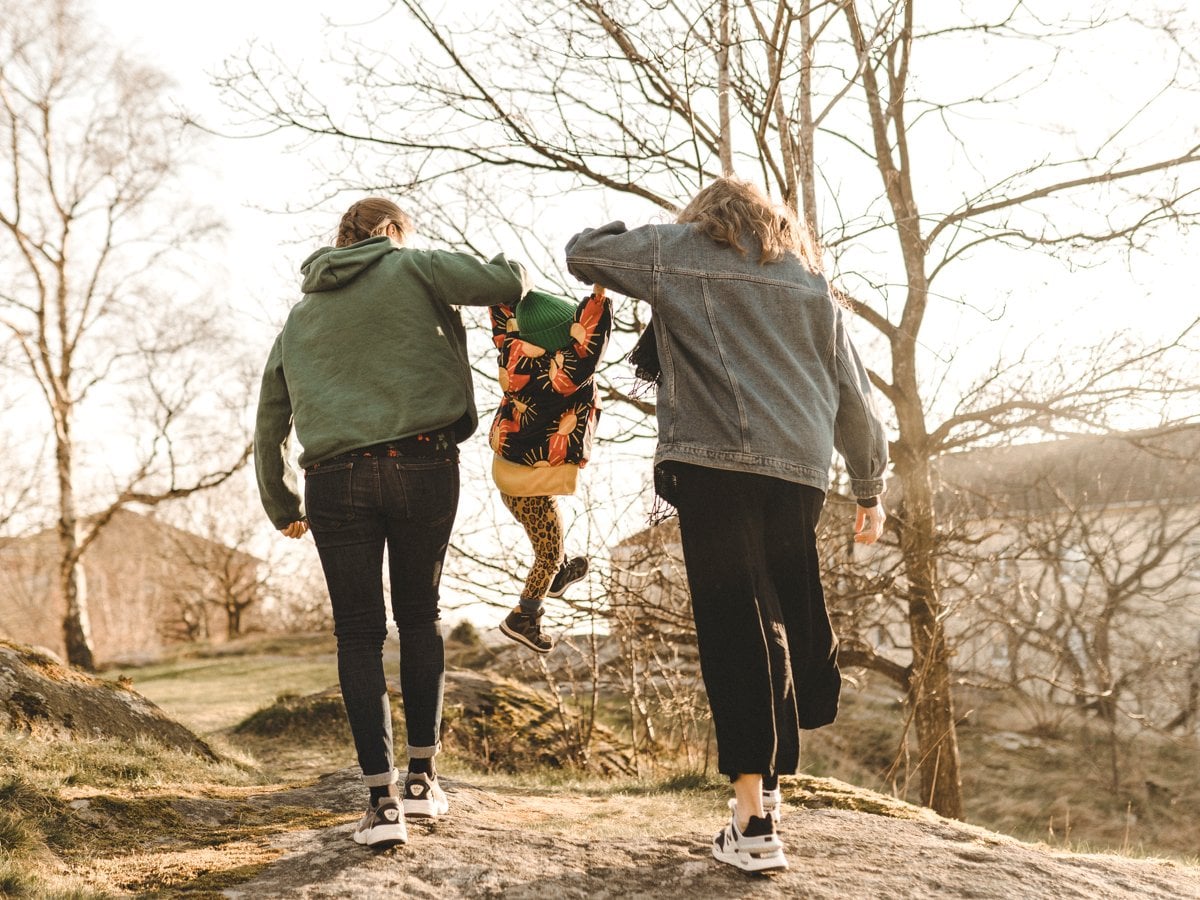 Två vuxna lyfter upp sitt barn emellan dom