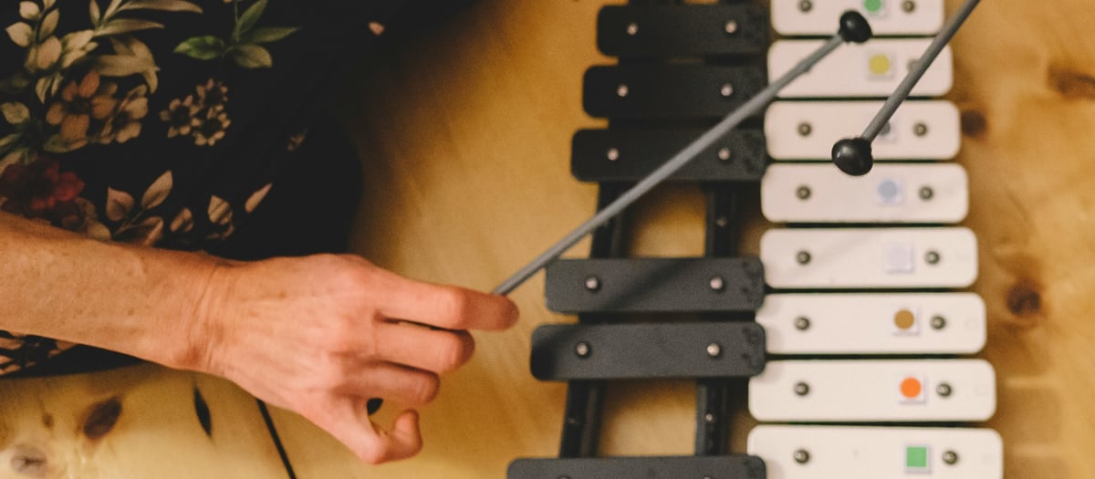 En person som spelar ett musikinstrument på ett trägolv.
