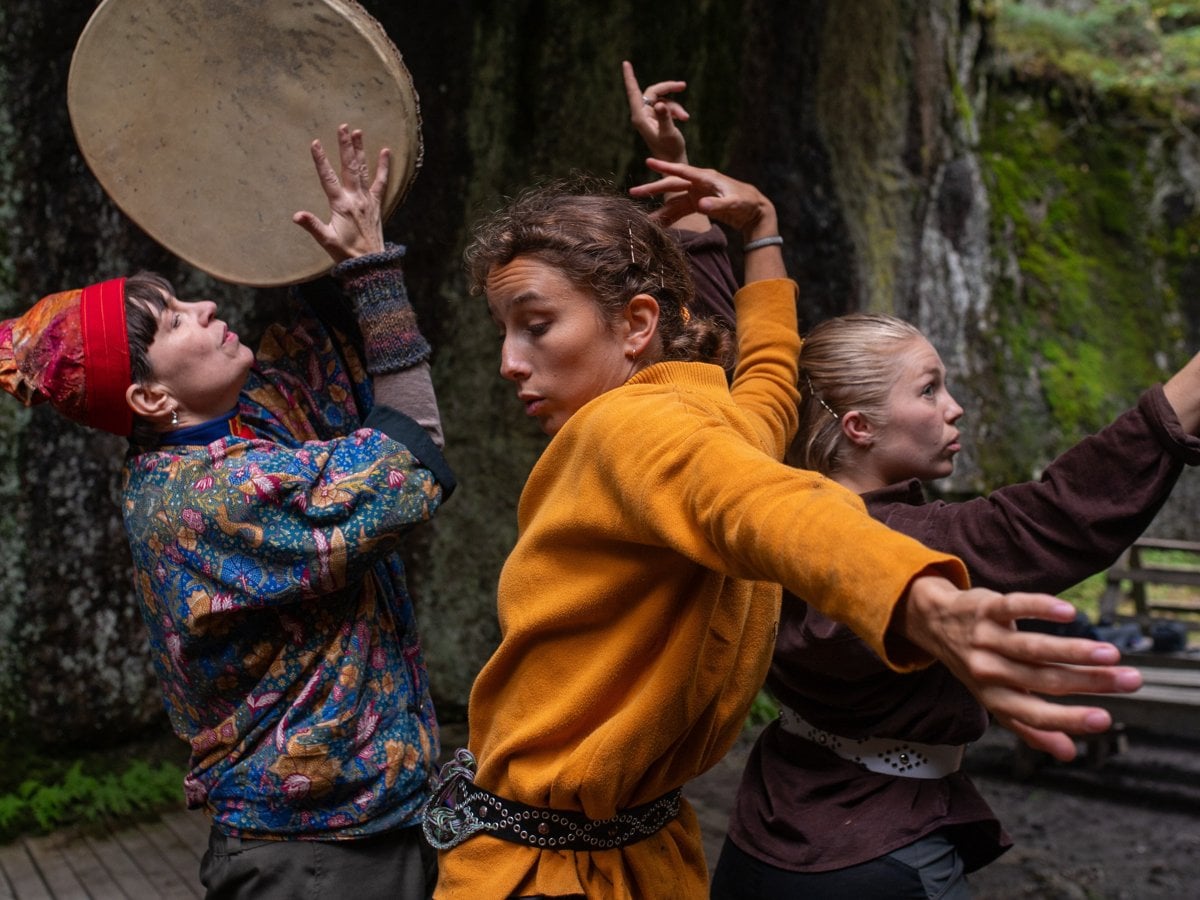 Tre dansare i skogsmiljö.