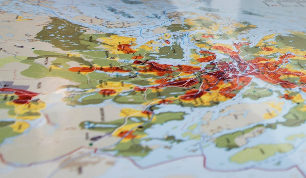 Kvinna kollar på karta över Stockholms län