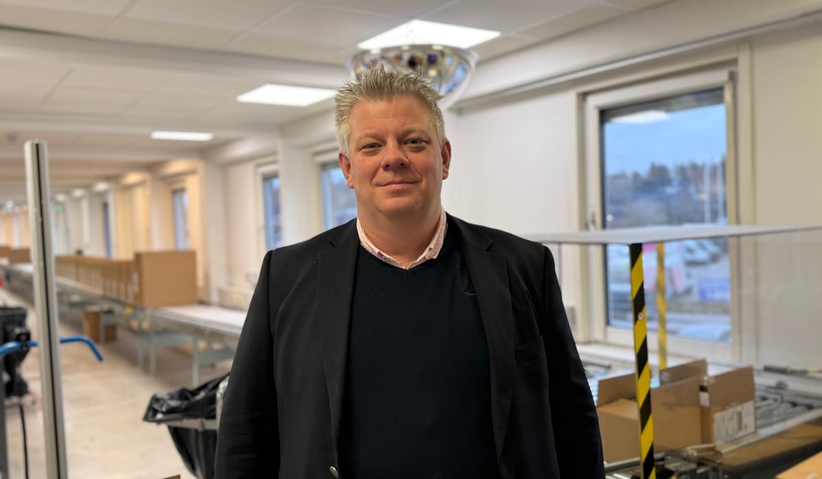 En man som står i ett rum med lådor på golvet.