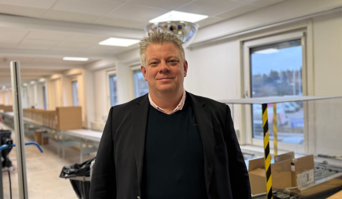 En man som står i ett rum med lådor på golvet.
