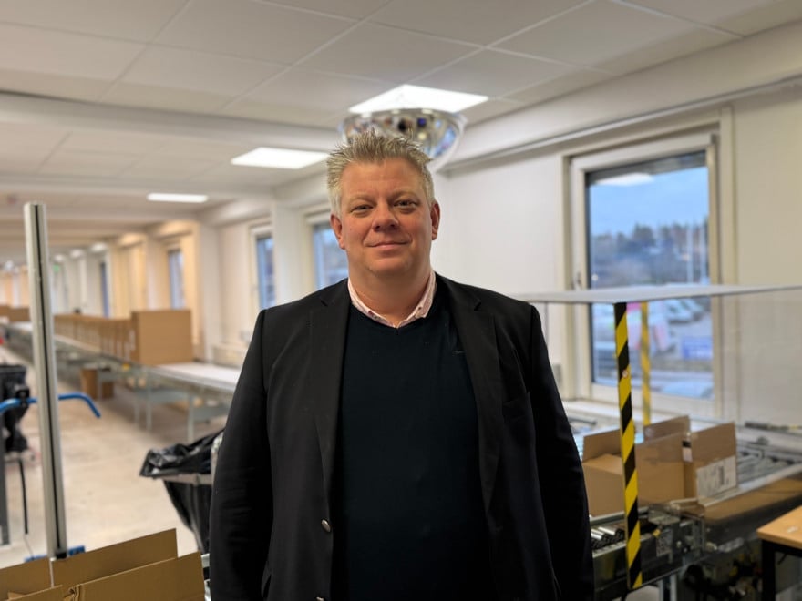 En man som står i ett rum med lådor på golvet.