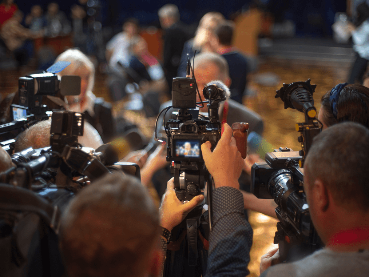 Journalister och fotografer intervjuar person