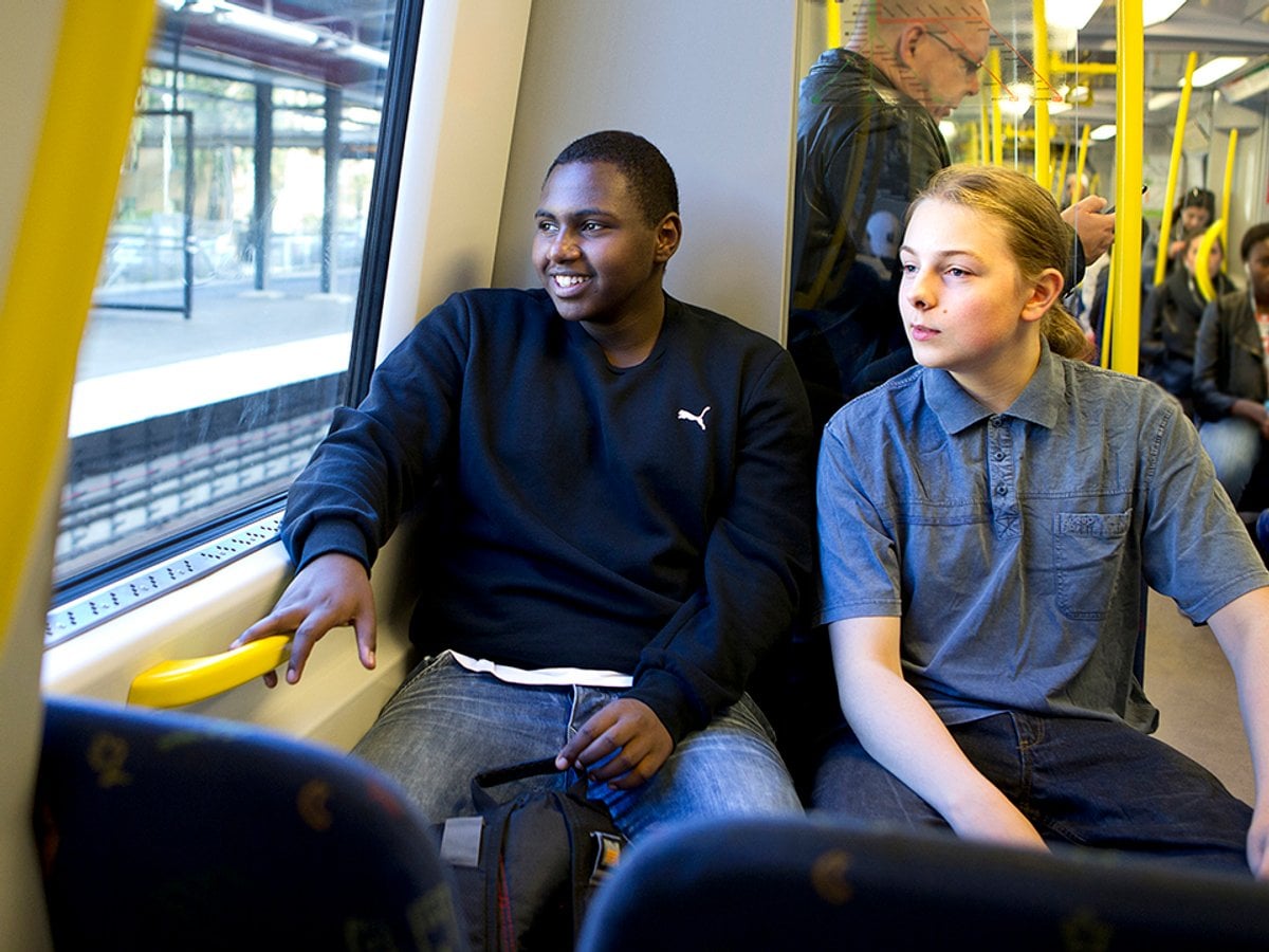 Två glada ungdomar åker tunnelbana.