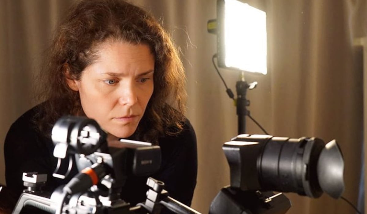 En kvinna filmar med en digital filmkamera med lampa