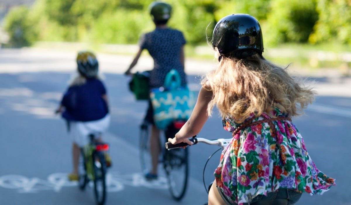 En grupp människor som cyklar längs en gata.