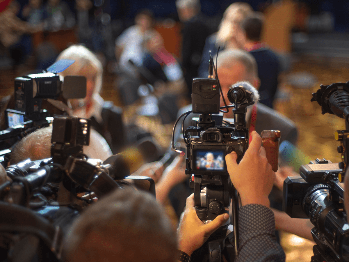 Journalister och fotografer intervjuar person
