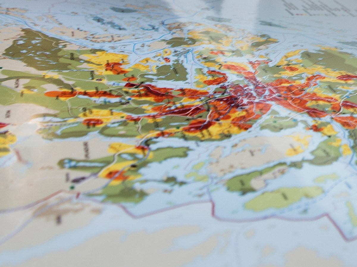 Kvinna kollar på karta över Stockholms län