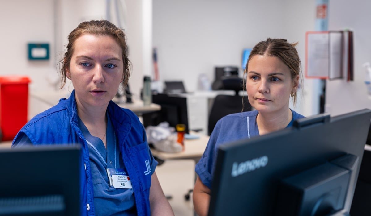 Vårdpersonal sitter framför datorskärmar.