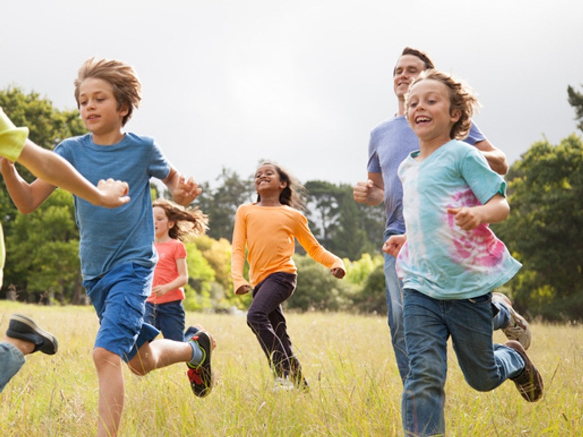 Barn springer över en äng