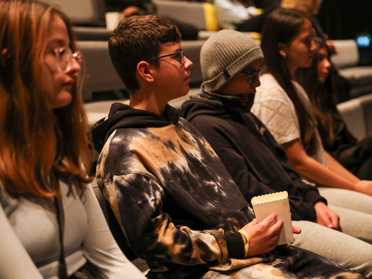 Skolelever som sitter i en biograf och lyssnar på en filmpedagog