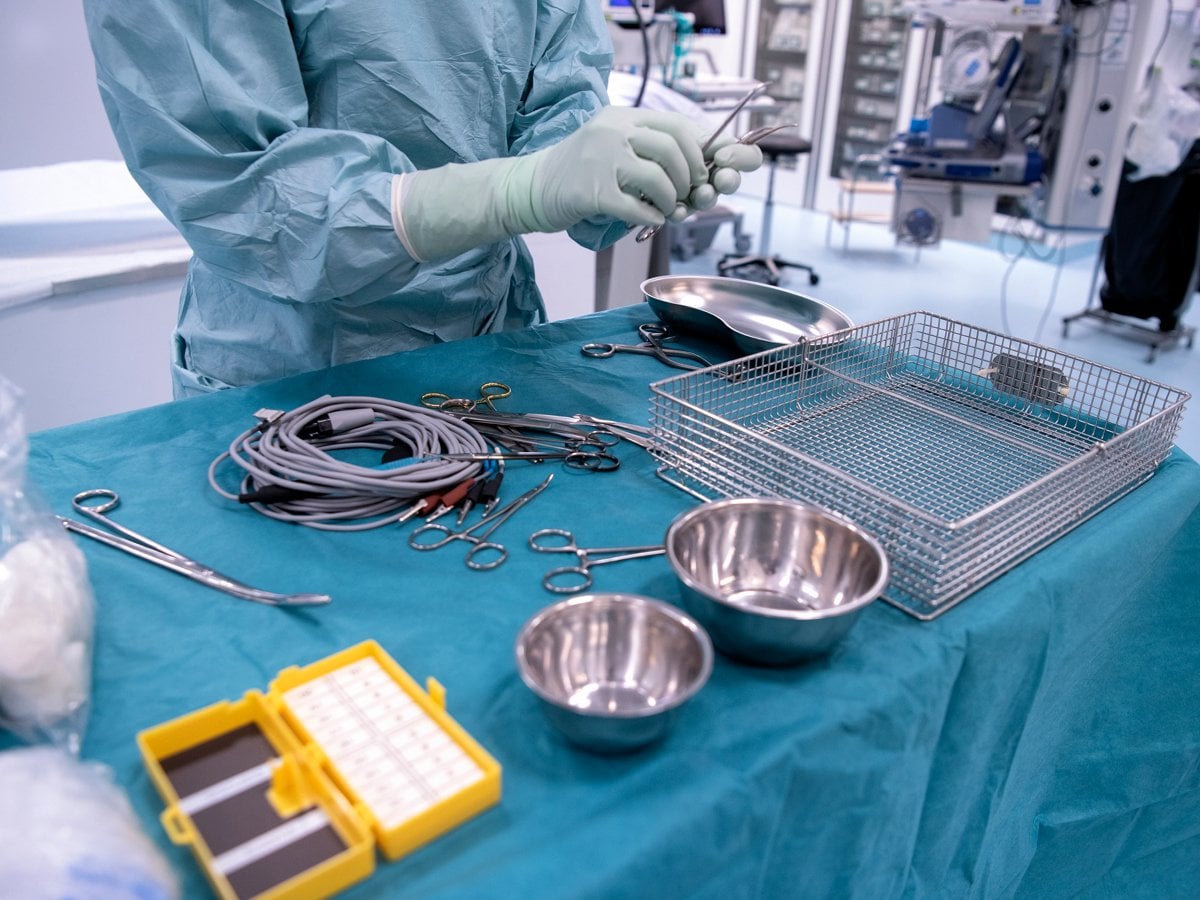 Närbild på instrument som används vid operation. En person står och håller i ett av instrumenten.