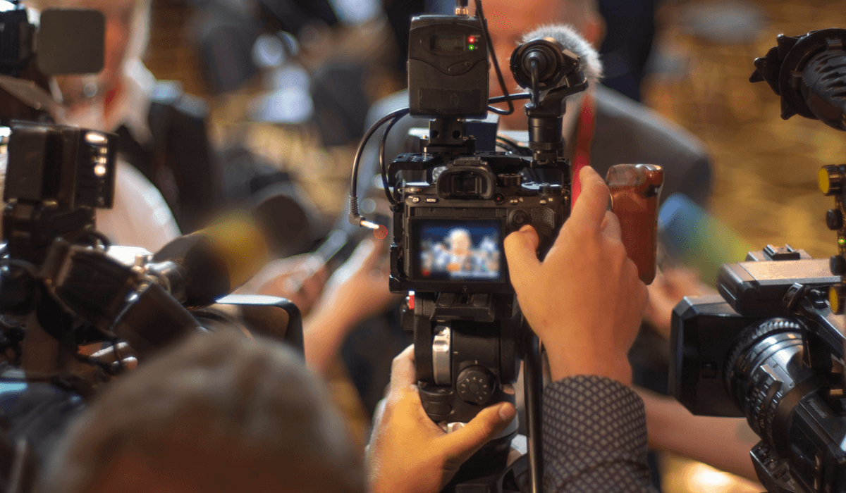 Journalister och fotografer intervjuar person