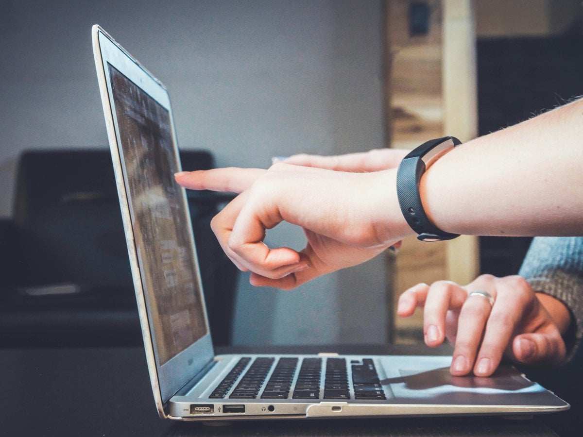 Händer som pekar på en datorskärm
