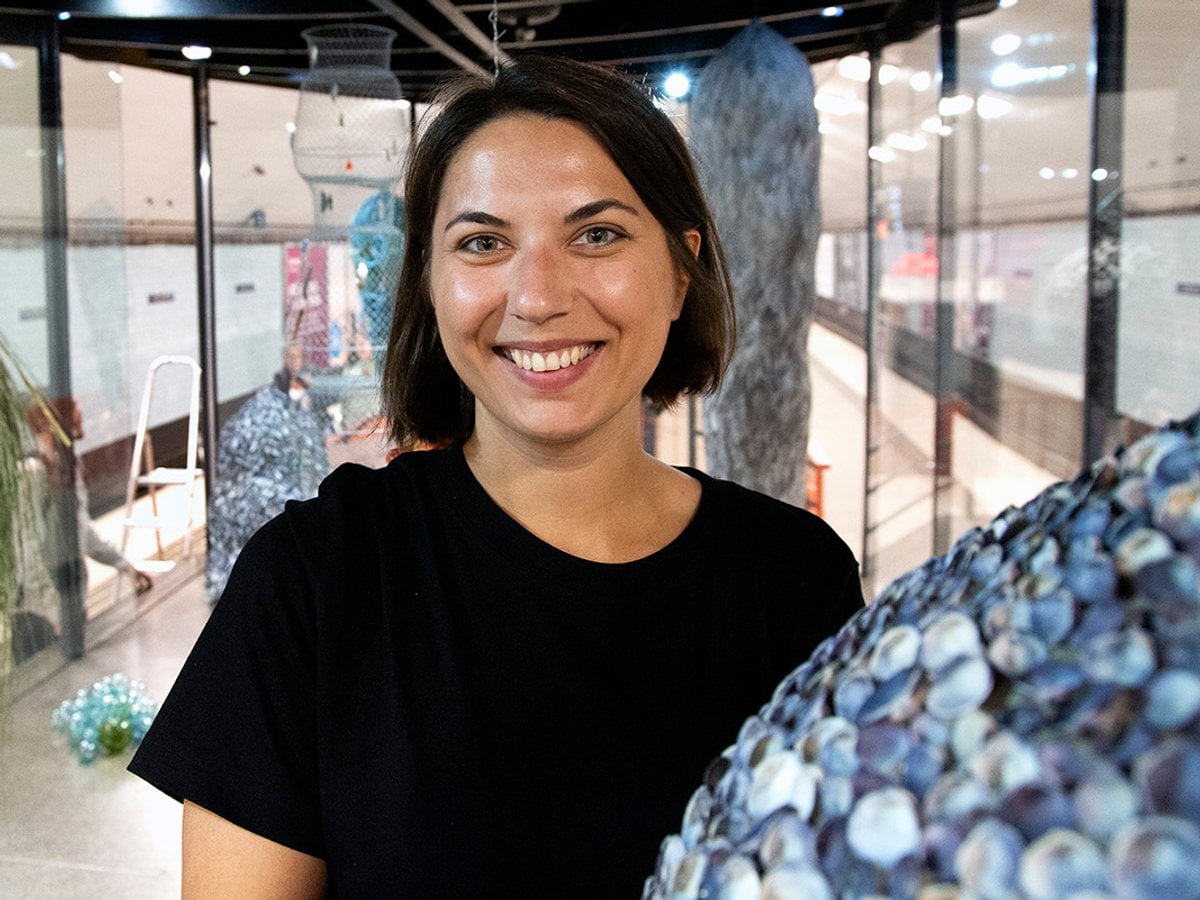 Anastasia i montern bredvid en skulptur av snäckskal.