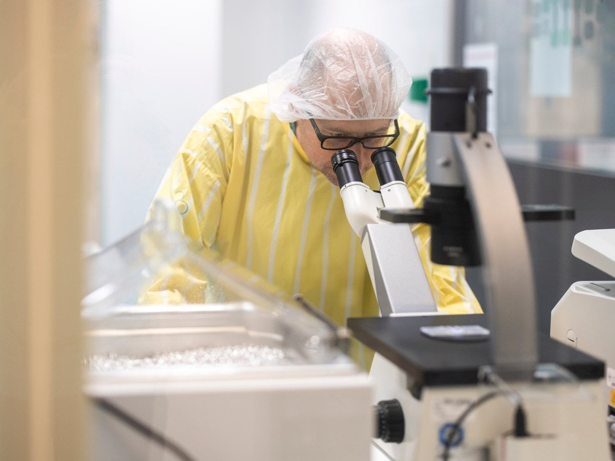 Bild på förmodad forskare som tittar i ett förstoringsglas