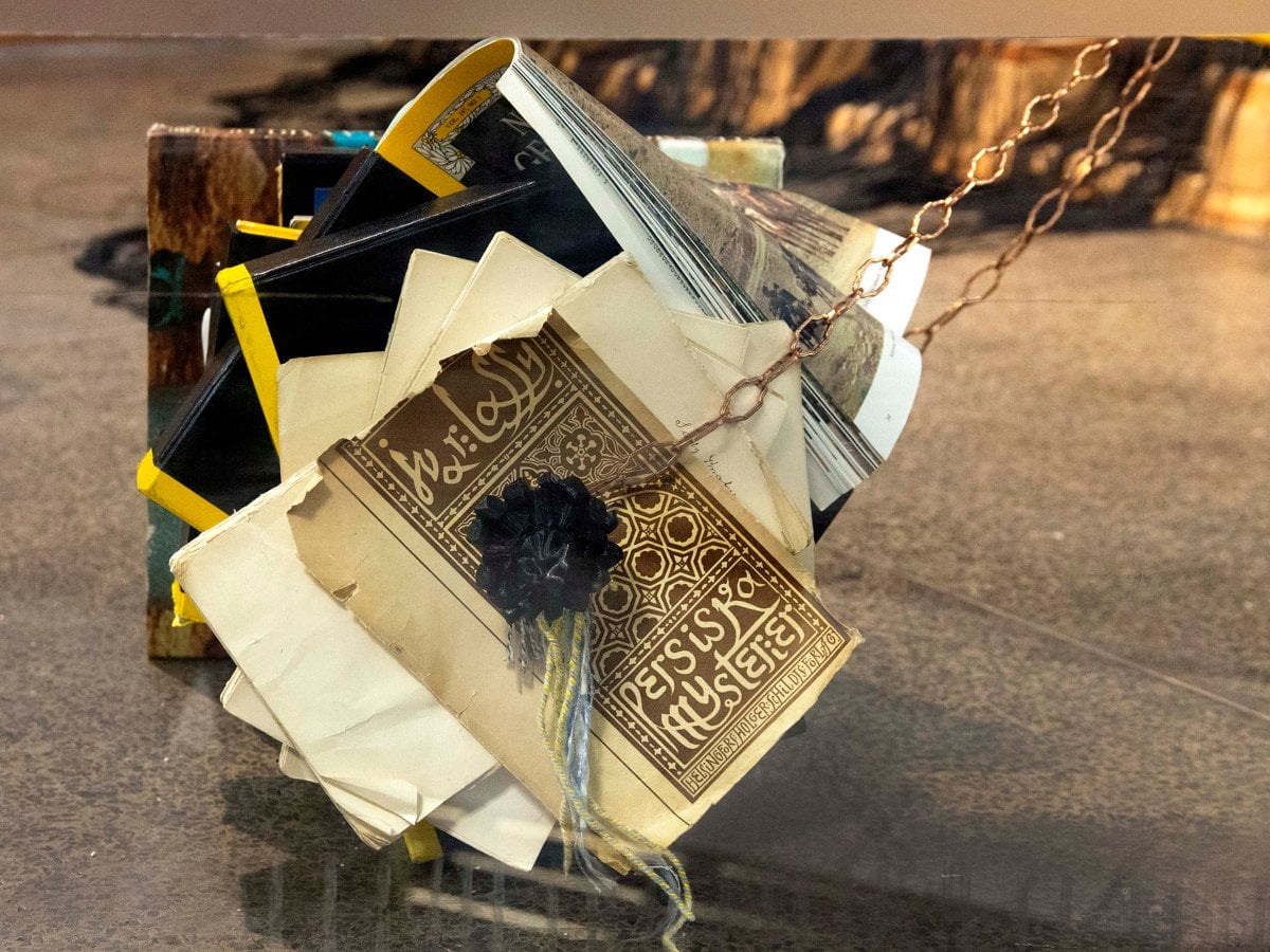 Installation i montern. Ljuskrona av skräp. Boktyngder som håller upp kronan.