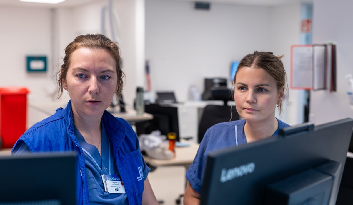 Några kvinnor som arbetar inom vården står framför datorer.