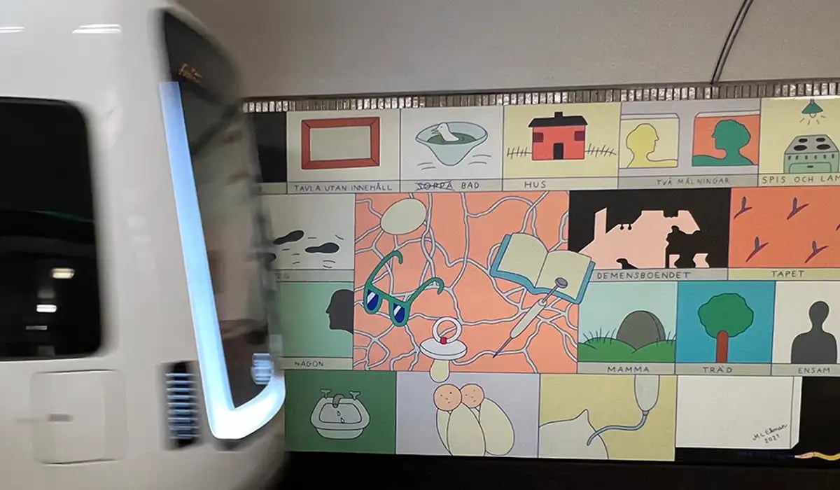 Tåg framför konst i tunnelbanan.