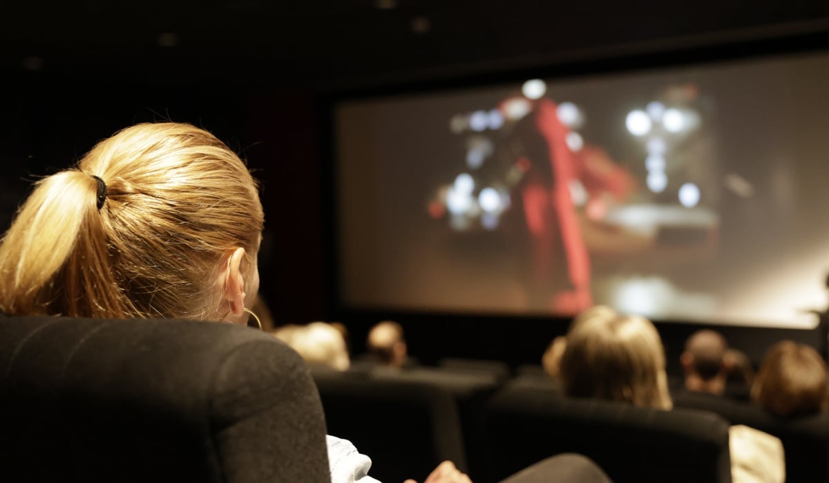 Personer som sitter i en biografsalong och tittar på film