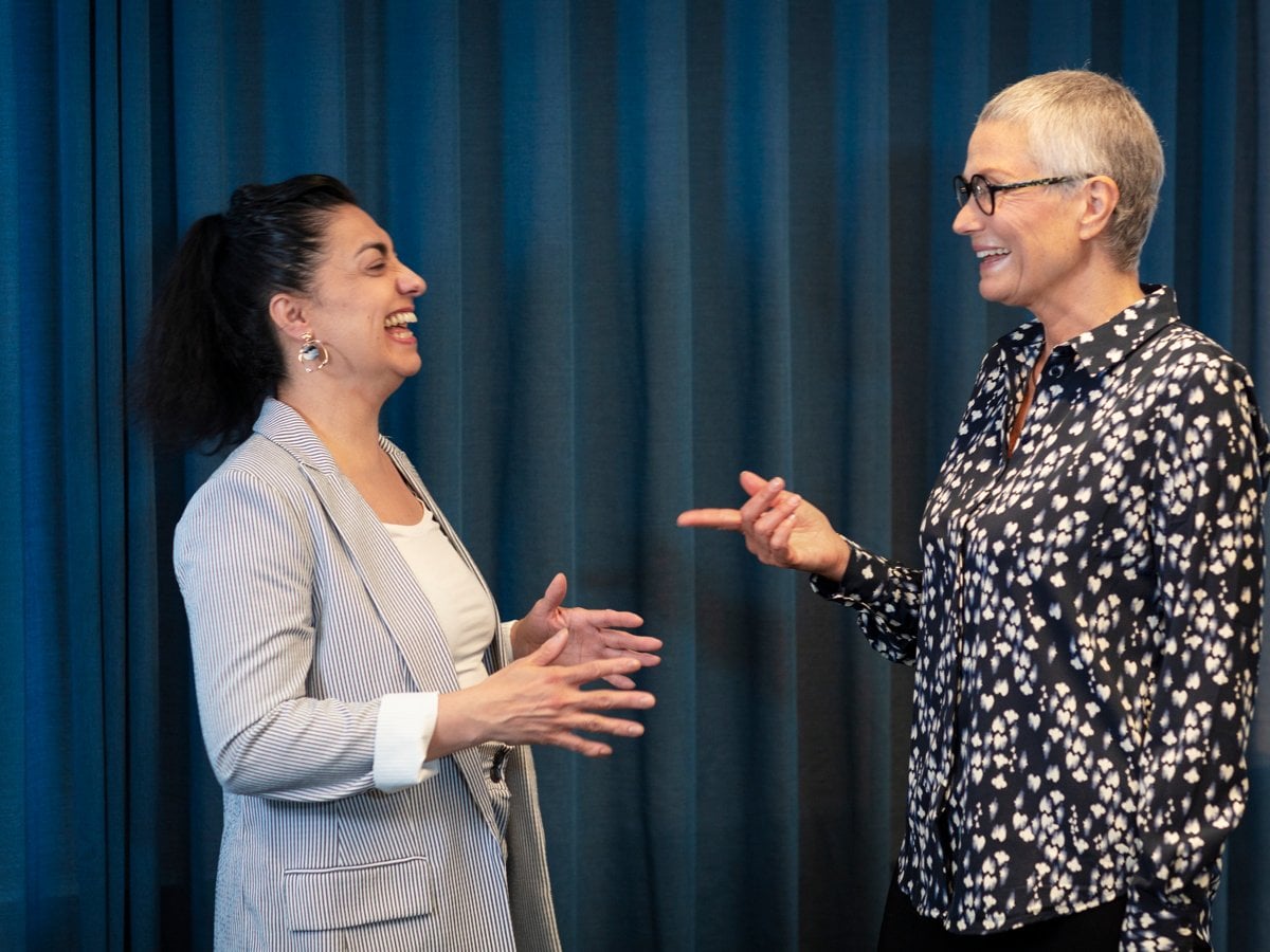 Två kvinnor samtalar med varandra under en utbildning.