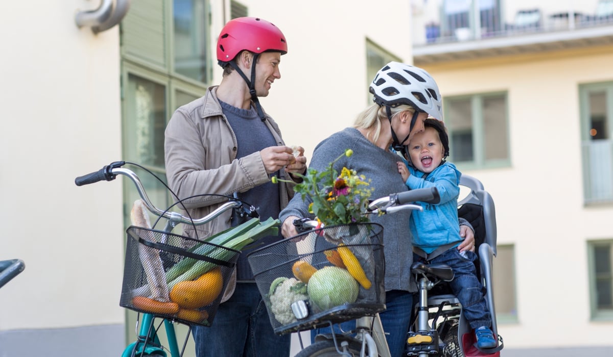 En man och en kvinna med ett barn på en cykel